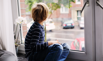 Young boy looking out of window