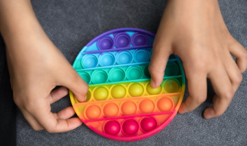 Child playing with rainbow pop-it