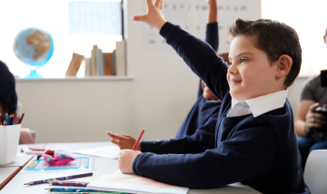 Children raising hands in class