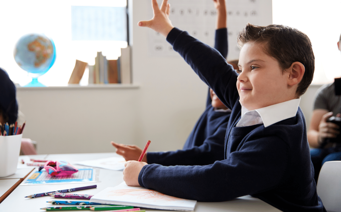 Children raising hands in class